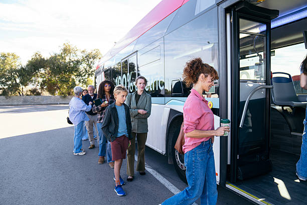Grupo de pasajeros abordando un autobús moderno en una parada.