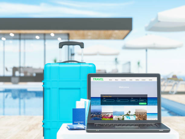 Laptop mostrando sitio web de viajes junto a maleta y pasaporte